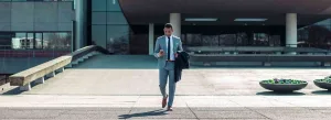 london outplacement header image of man walking out of the office looking at his phone